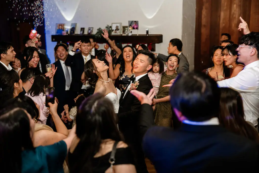 Large group of wedding guests dancing on the dancefloor.